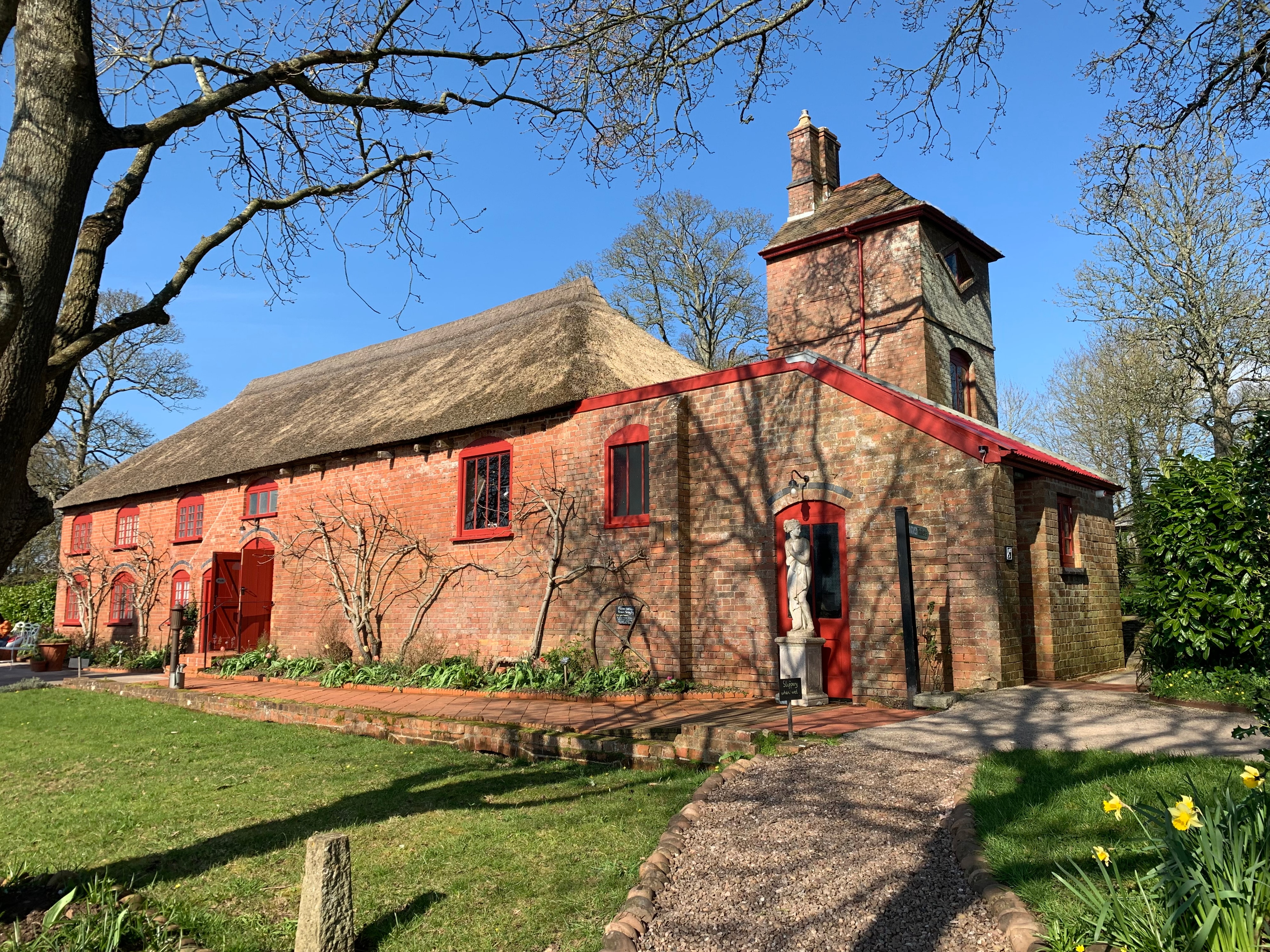 Red-Trimmed Thatched Building with Classical Statue
