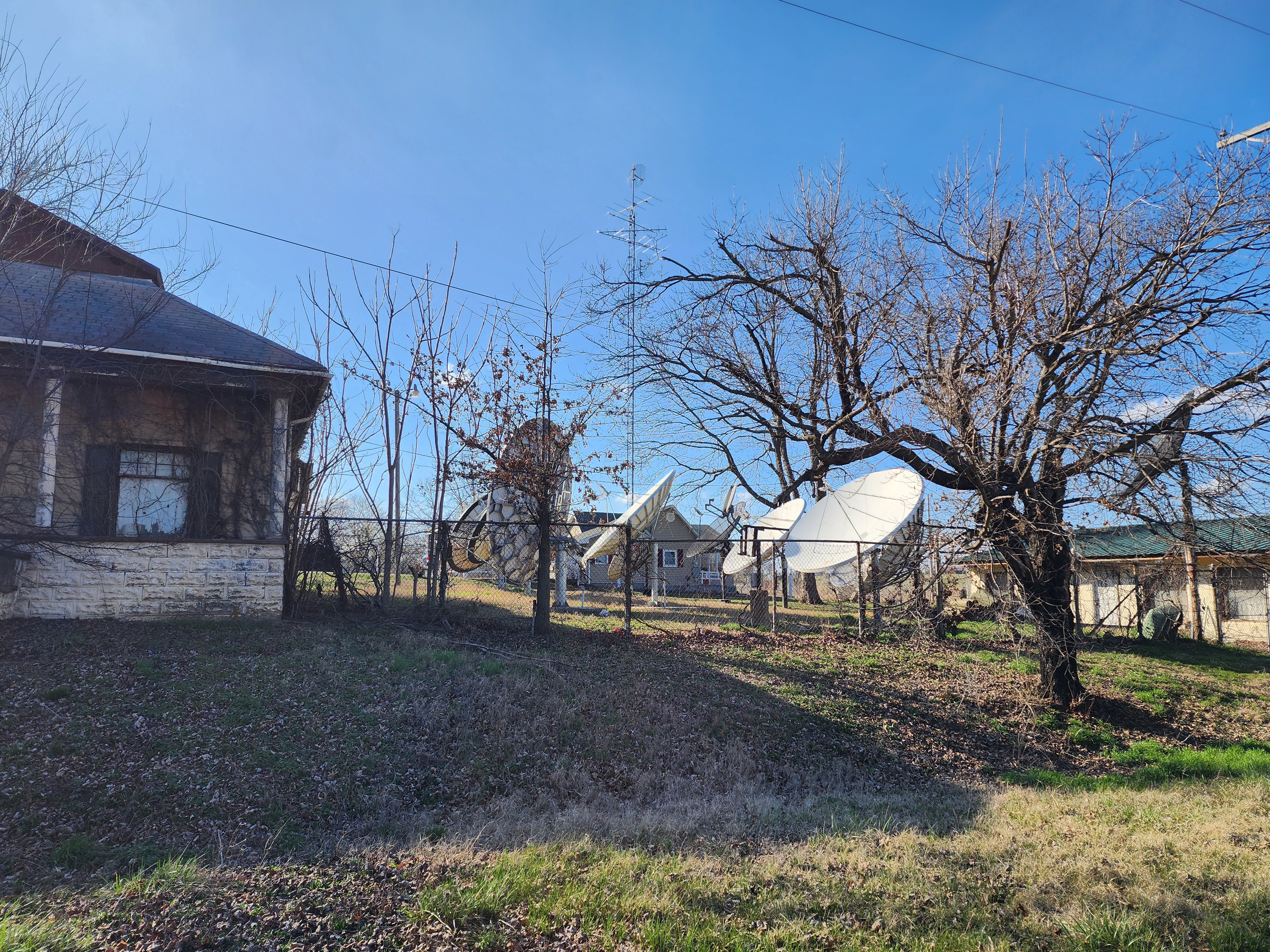 Satellite Dish Array Behind Weathered Stone House