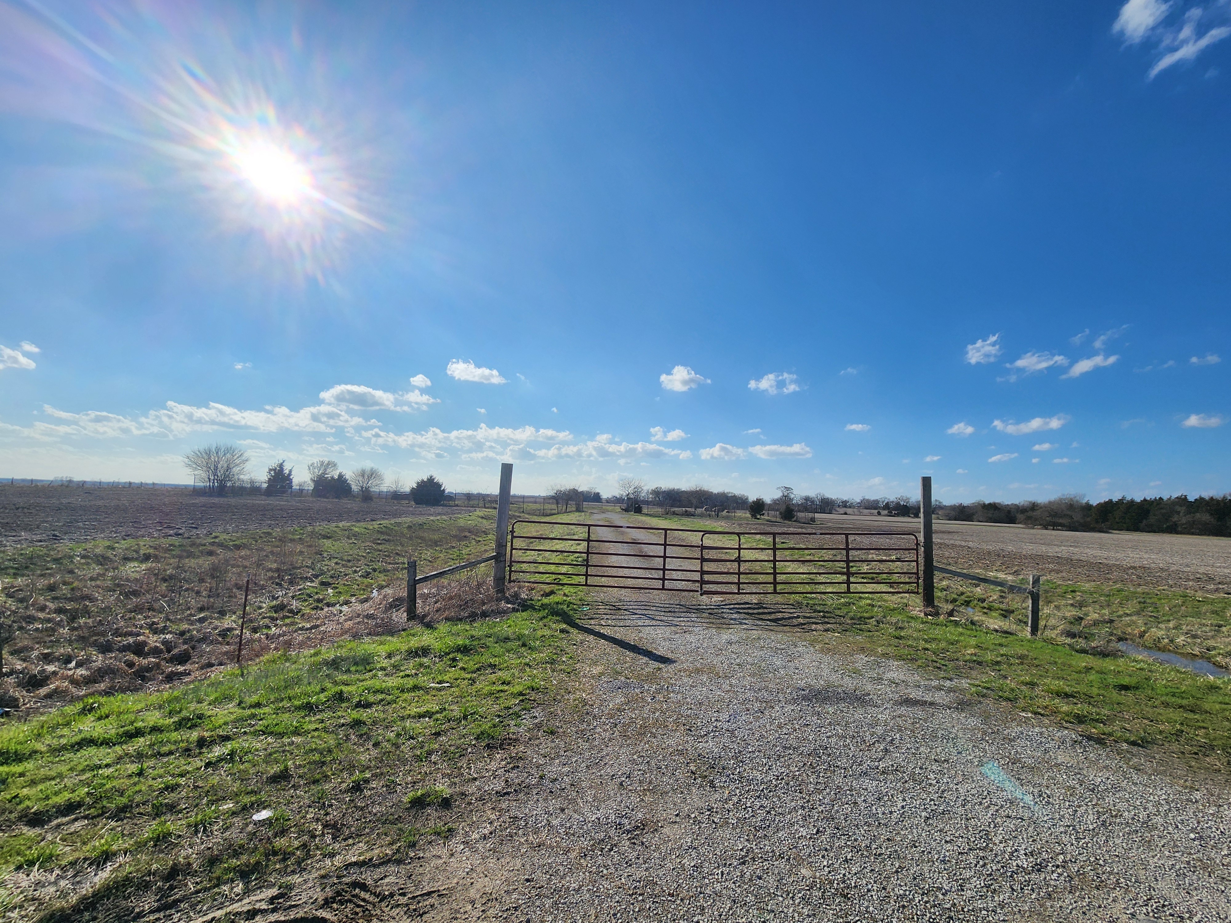 Red Tubular Steel Farm Gate on Gravel Field Entrance